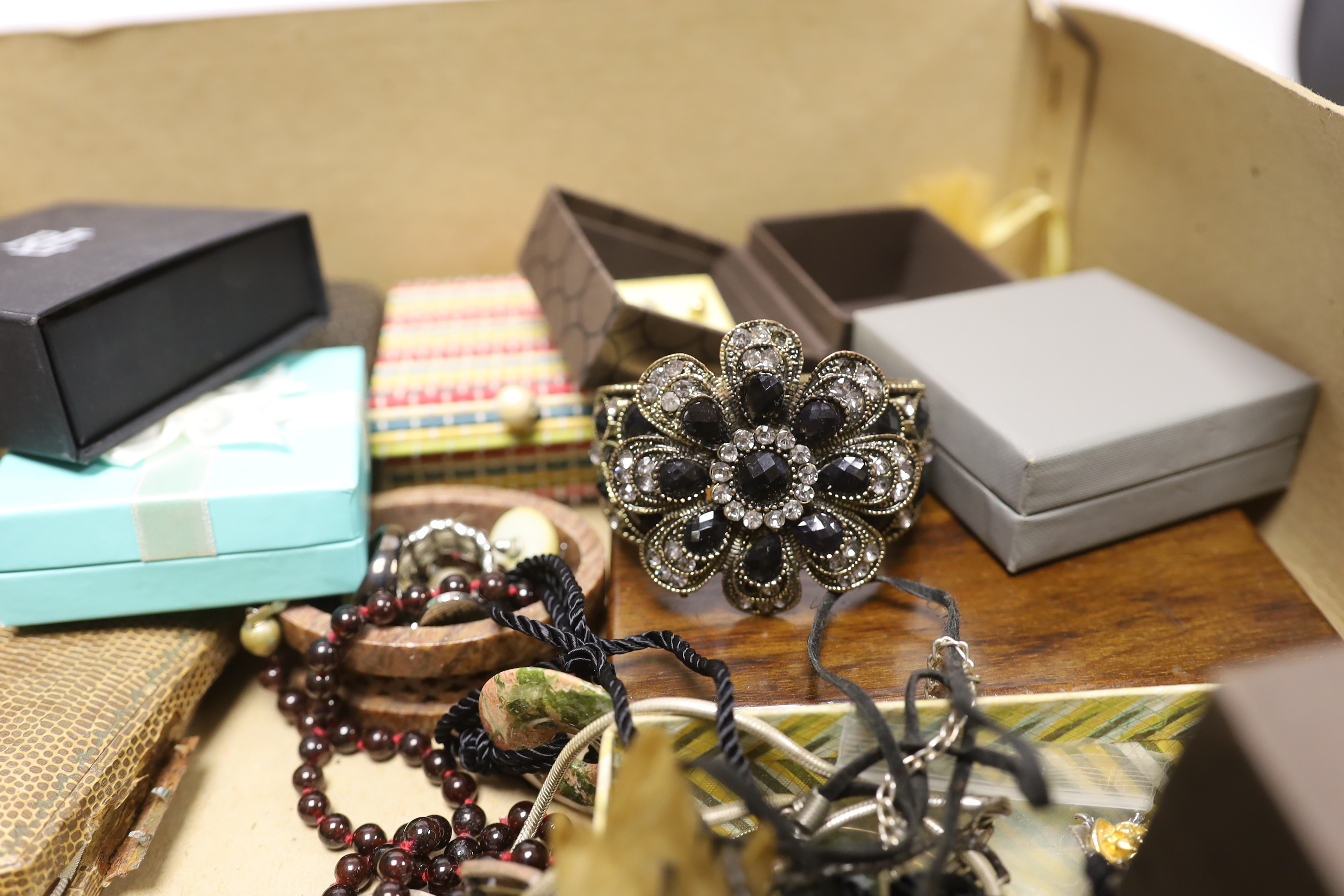 A group of assorted costume jewellery including a garnet necklace, amethyst pendant, etc.